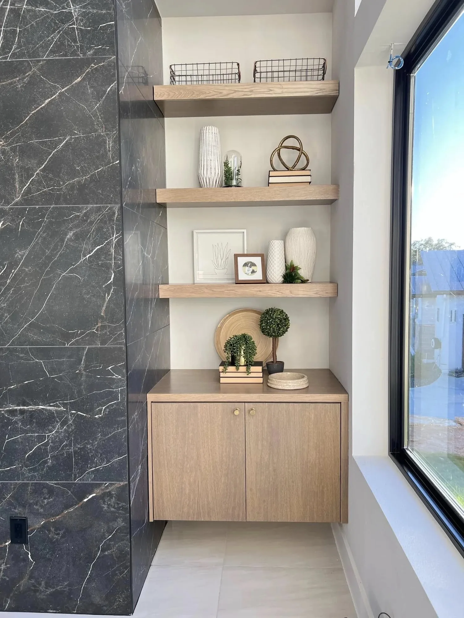 Floating shelves with a marble accent wall