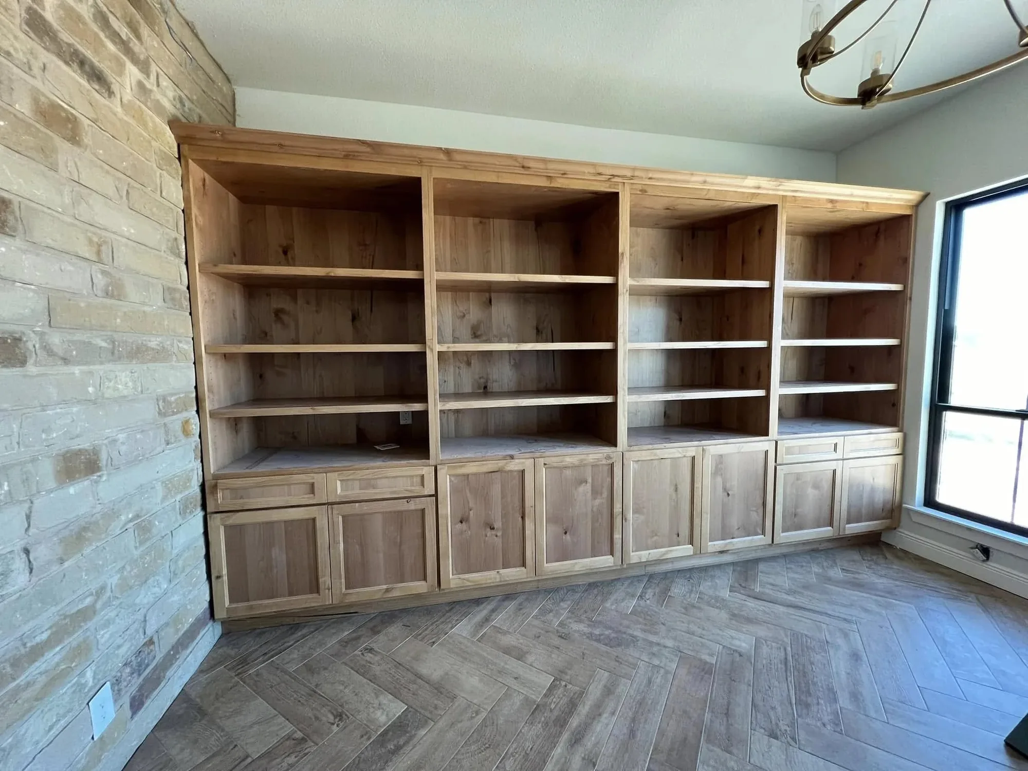 Full wall of natural wood built-in shelving and cabinets