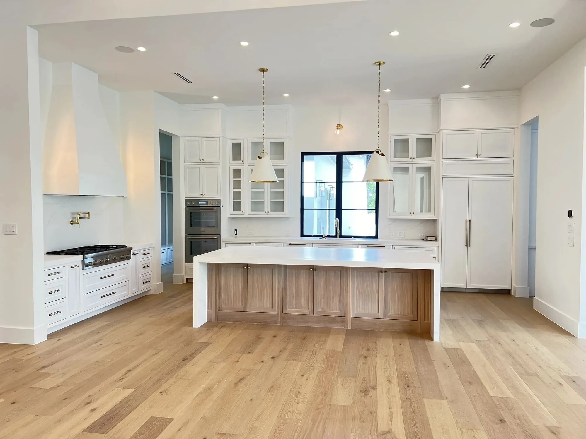 White kitchen cabinets with a wood topped island